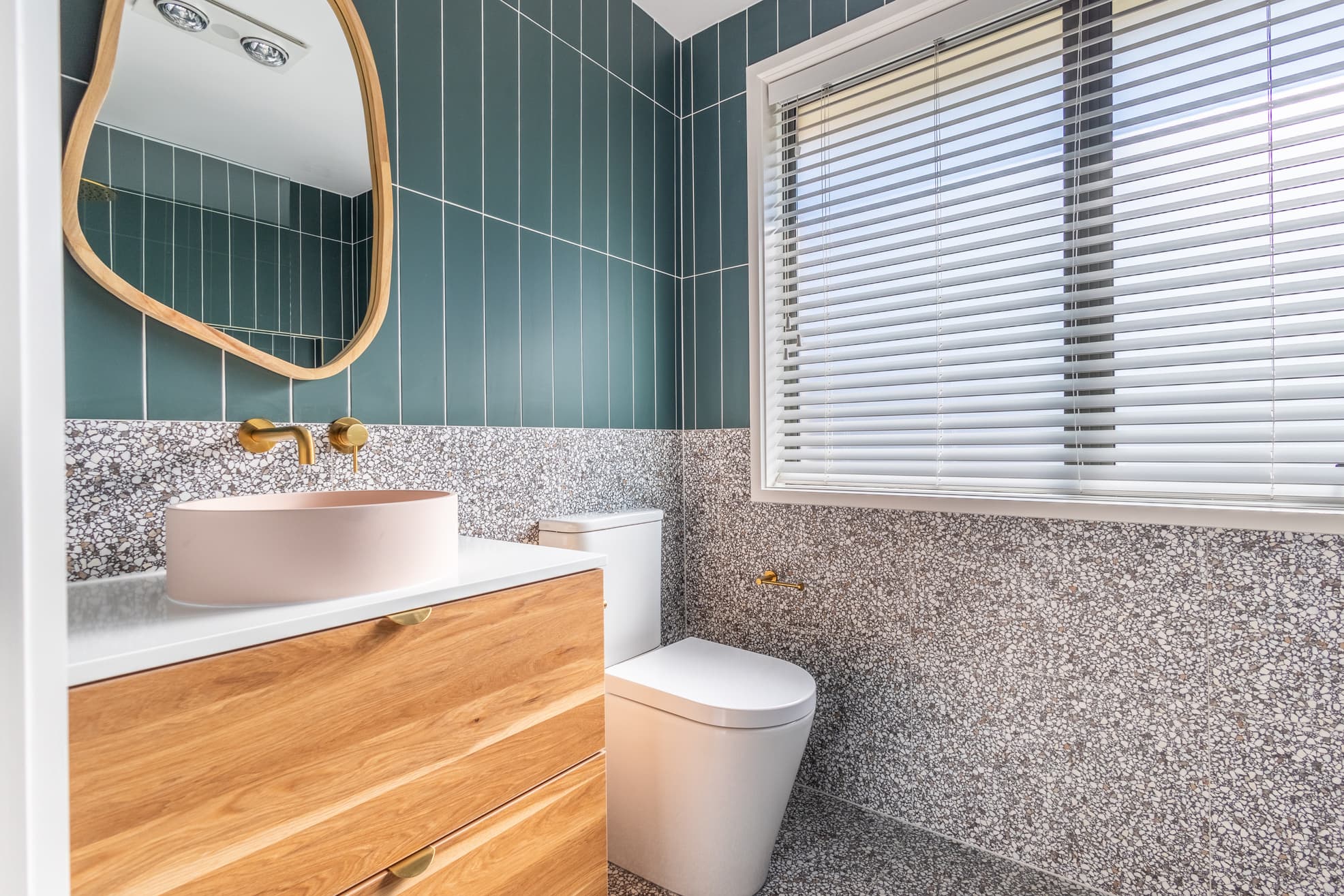 Modern bathroom with teal tiles and gold fixtures